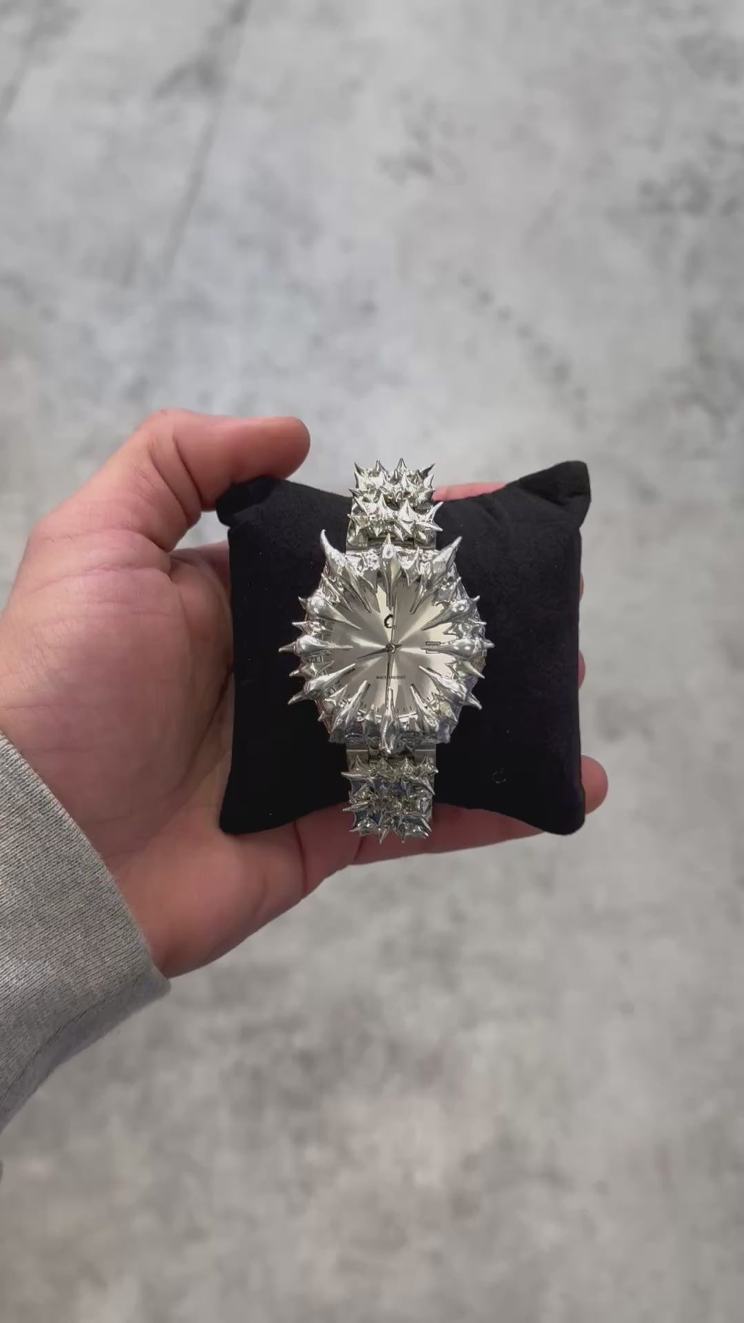Crystal Spire chrome spiked watch displayed on a black cushion, showcasing its edgy stainless steel construction and quartz precision.