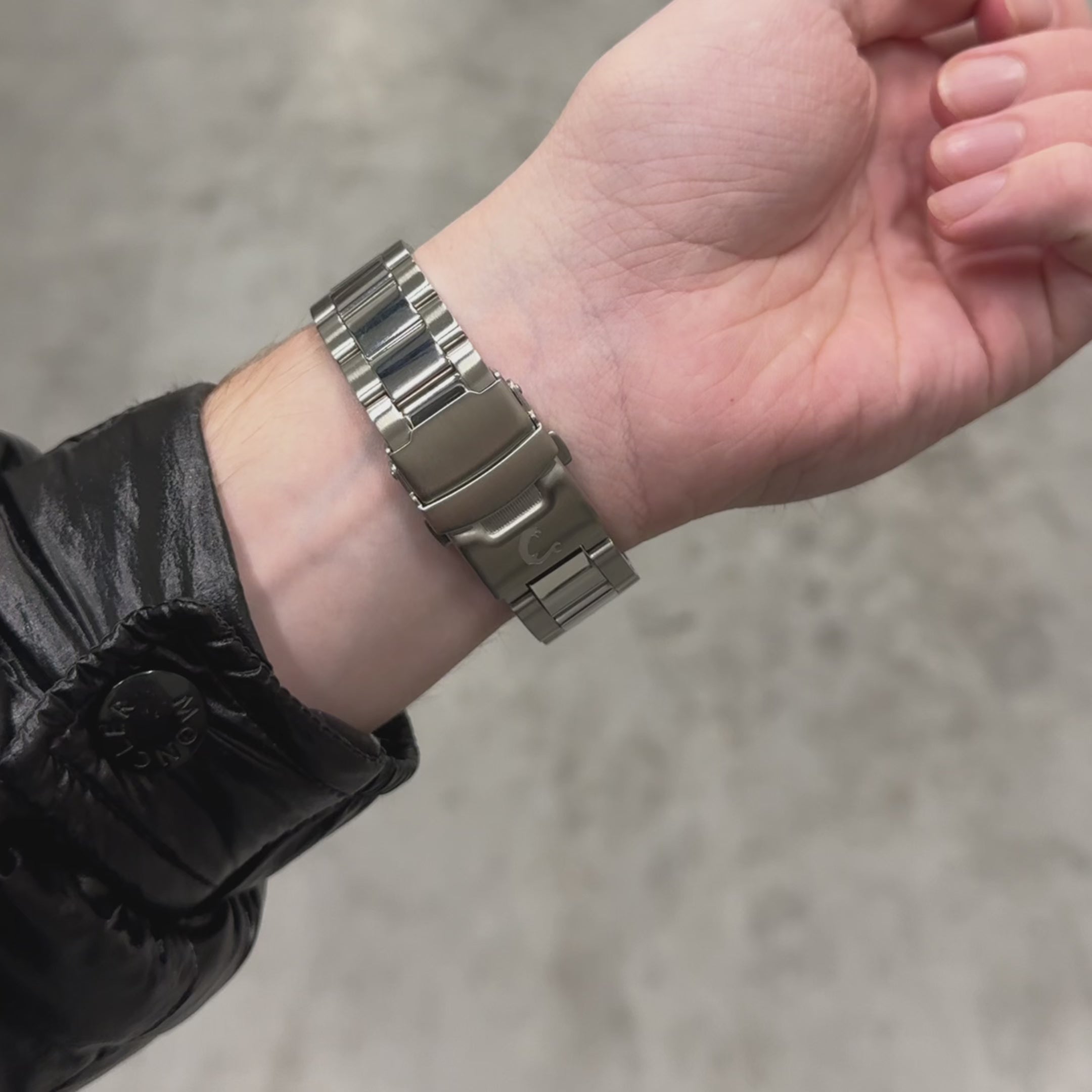 Close-up of RUBY watch stainless steel clasp on wrist, highlighting secure fit and polished bracelet design.