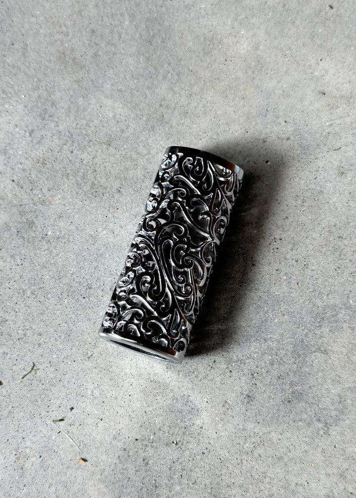 Silver Scrolls Case - Polished Silver Scroll lighter case with intricate scrollwork design, shown on a concrete surface for texture contrast.