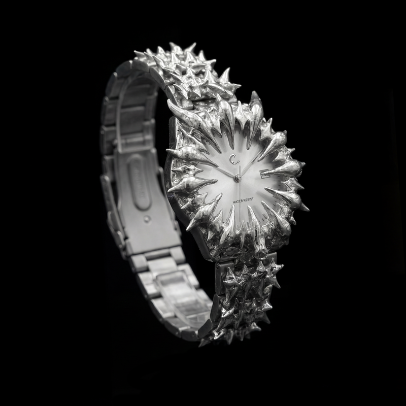 Luxury chrome watches with intricate, spiked crystal designs in display boxes.
