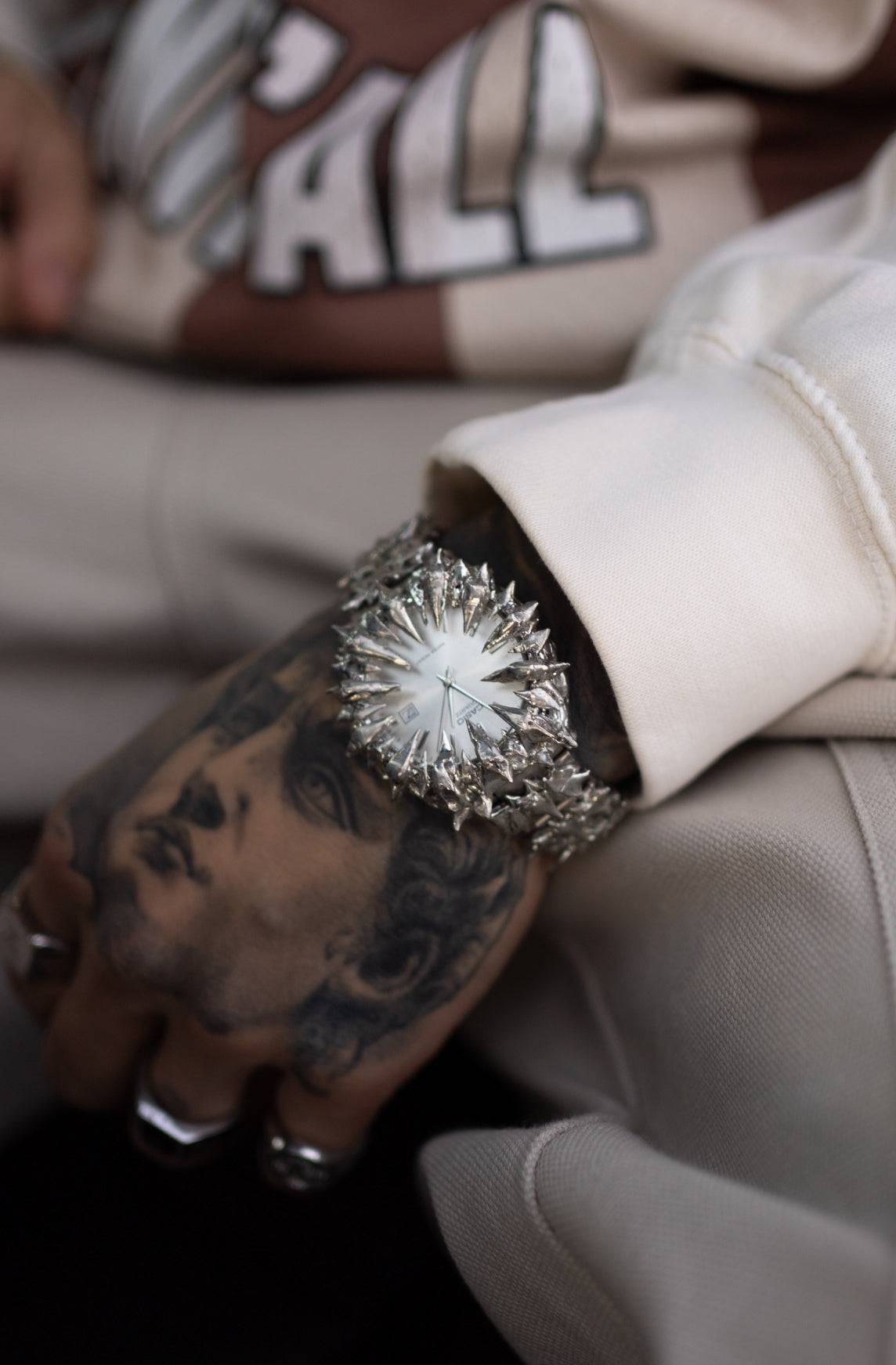 Crystal Spire spiked watch worn on wrist, highlighting its aggressive chrome design and fashion-forward appeal in streetwear styling.